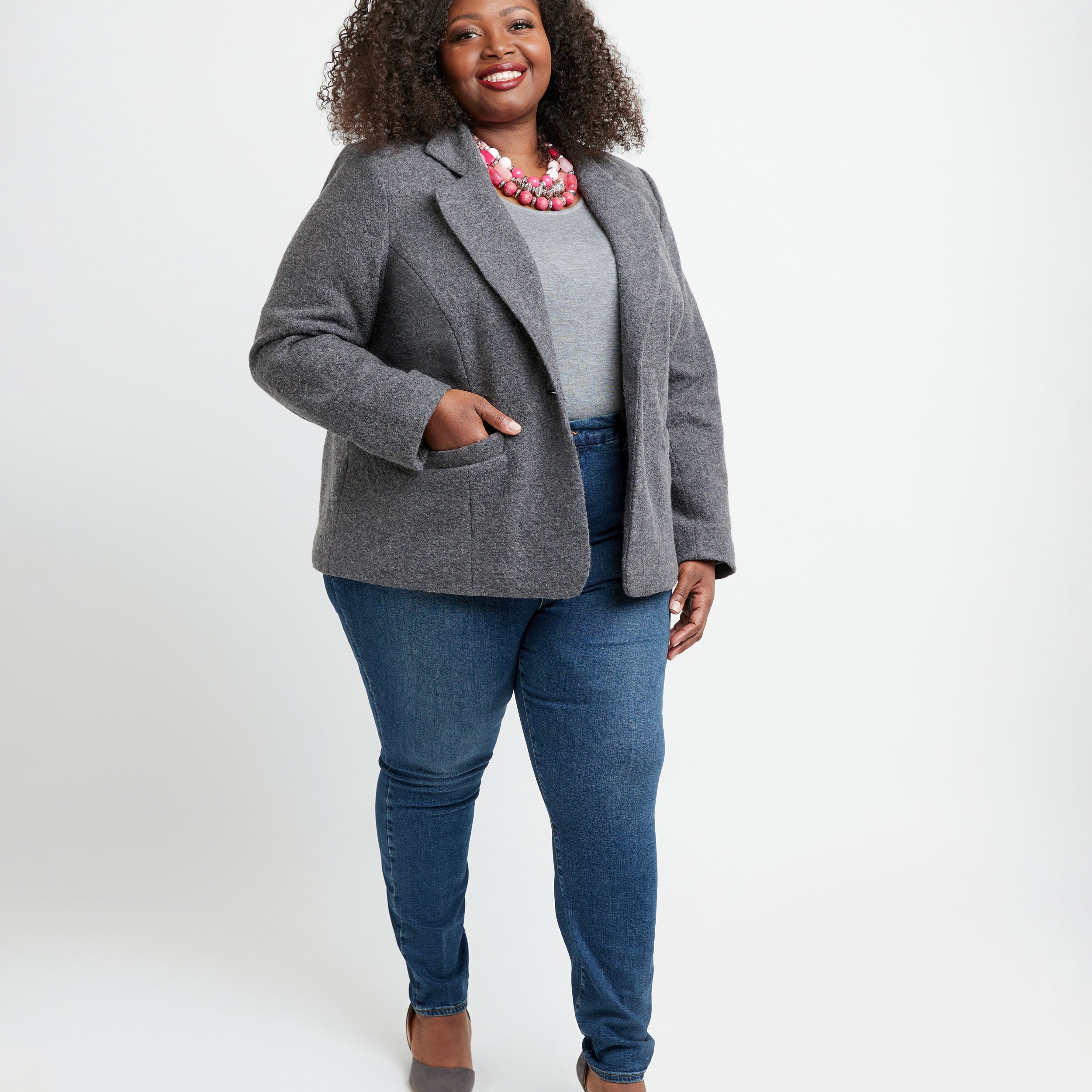 Woman wearing a gray blazer, white shirt, and blue jeans on a white background. This blazer is the Auburn Blazer sewing pattern from Cashmerette.