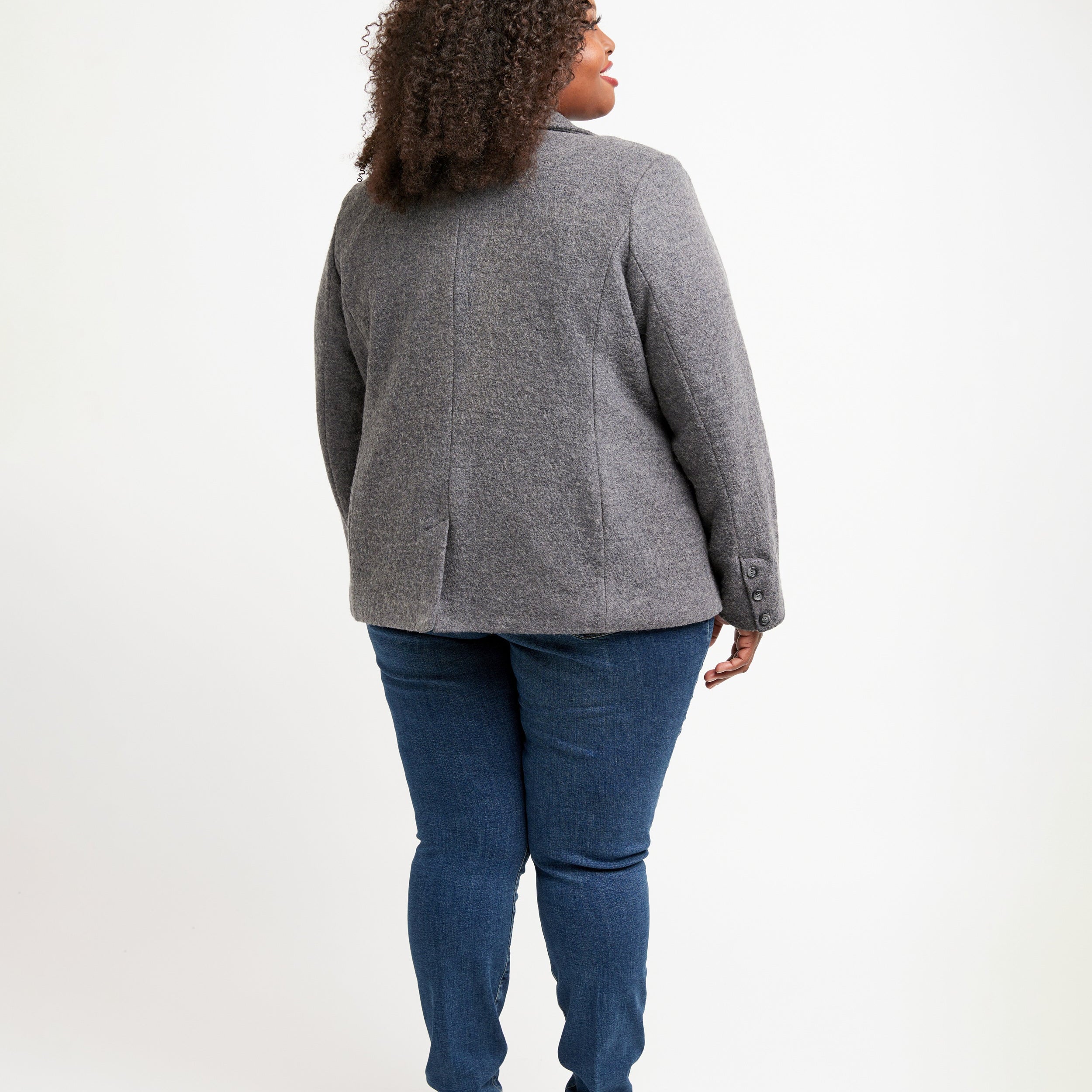Person wearing a gray blazer and blue jeans on a white background. This blazer is the Auburn Blazer sewing pattern from Cashmerette.