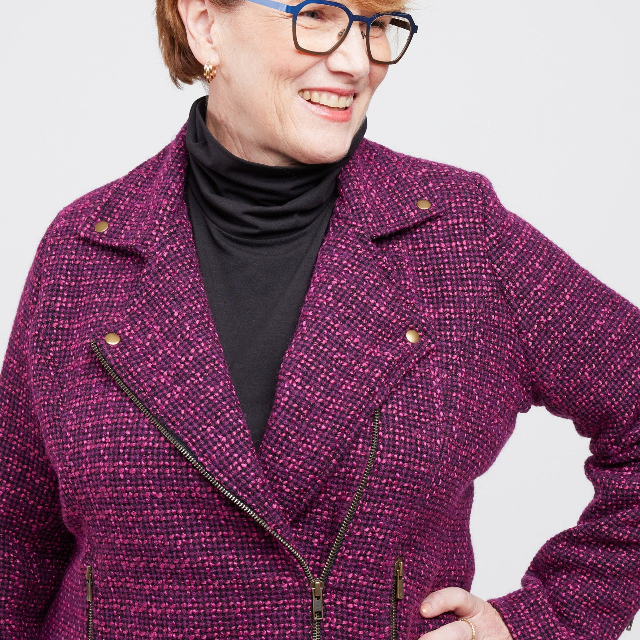 Woman wearing a purple coat with a plain background. This biker jacket is the Canton Moto Jacket sewing pattern from Cashmerette.