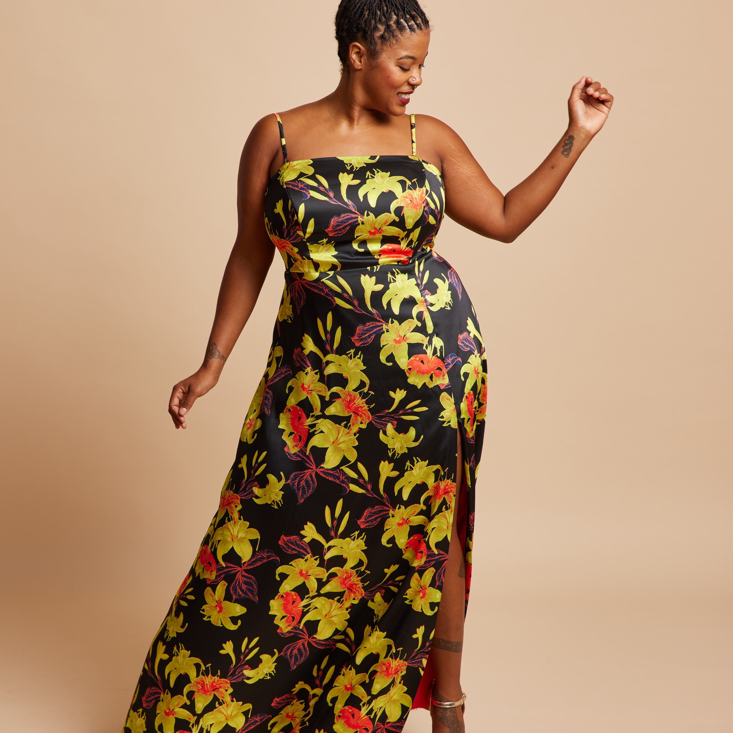 Woman wearing a floral dress on a beige background. This dress is the Ellington Strapless Dress sewing pattern from Cashmerette.