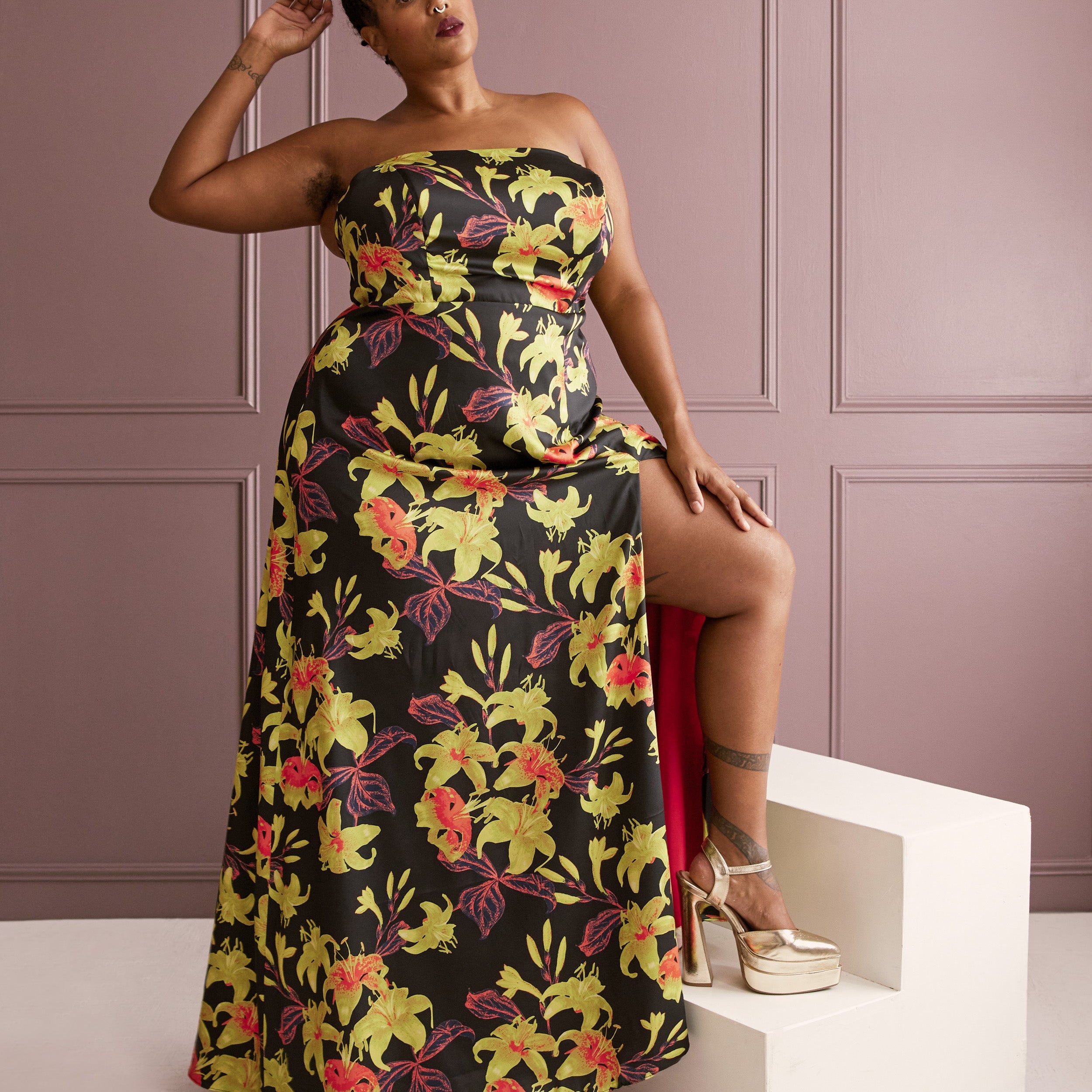 Woman wearing a floral strapless dress against a pink paneled wall. This dress is the Ellington Strapless Dress sewing pattern from Cashmerette.