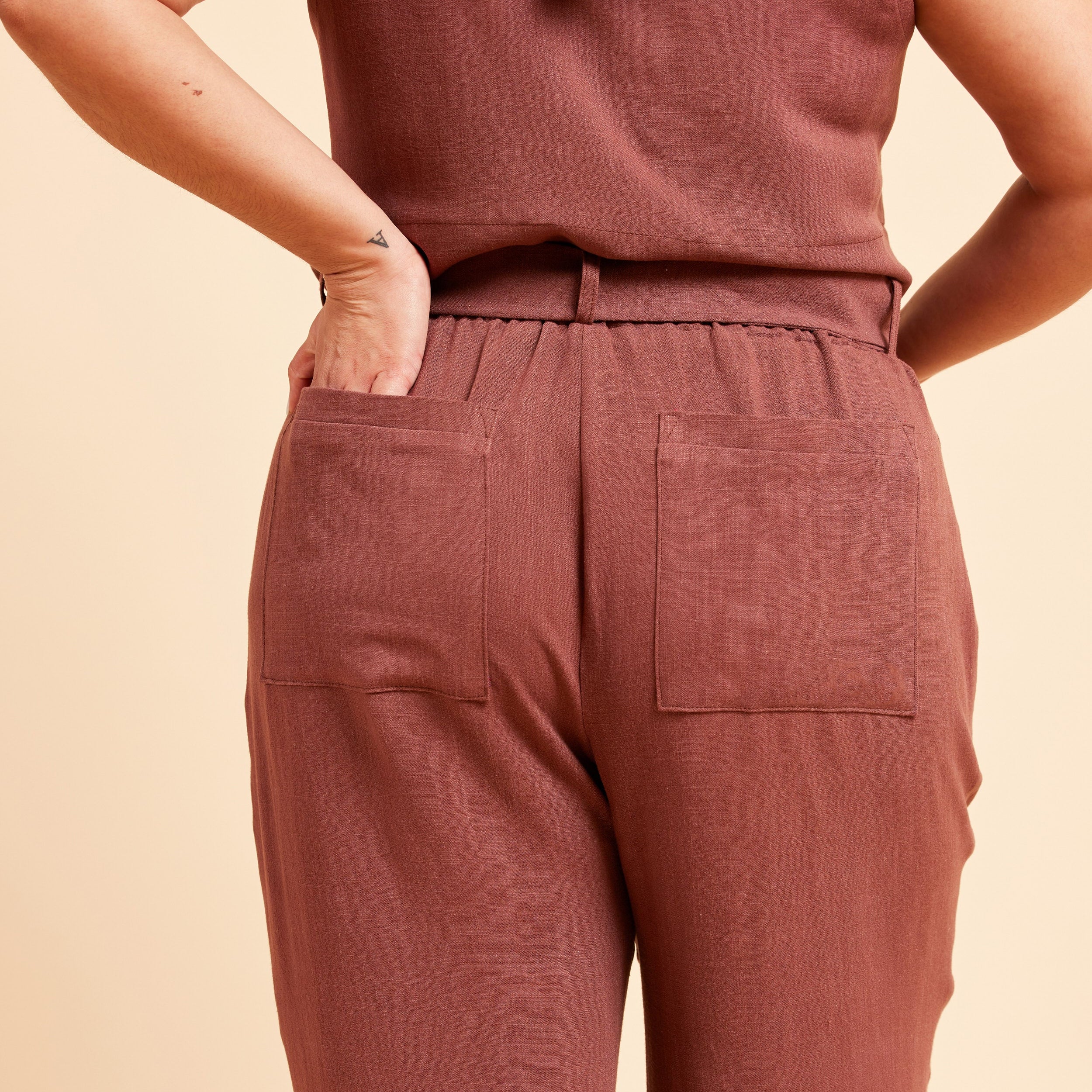 Person wearing a matching brown top and pants on a beige background. These pants are the Everett Pants & Shorts sewing pattern from Cashmerette.