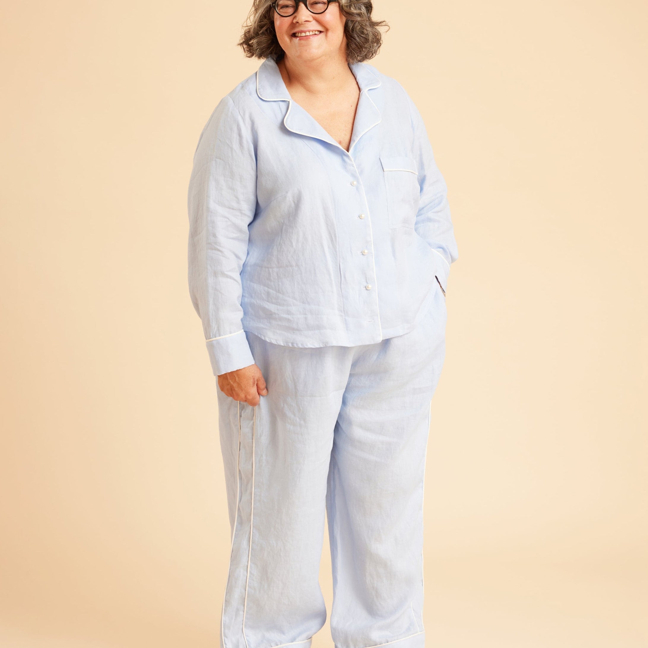 Person wearing a light blue pajama set on a beige background. This is the Fiske Sleepwear Set sewing pattern from Cashmerette.
