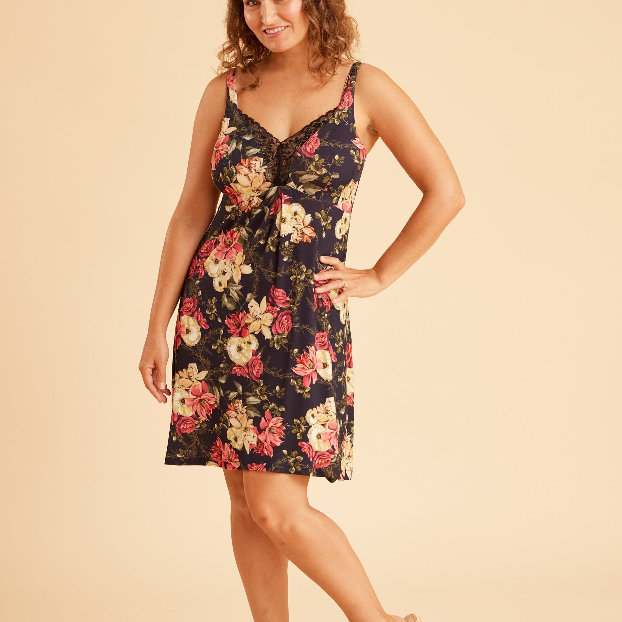 Woman wearing a floral dress on a beige background. This is the Fiske Sleepwear Set sewing pattern from Cashmerette.