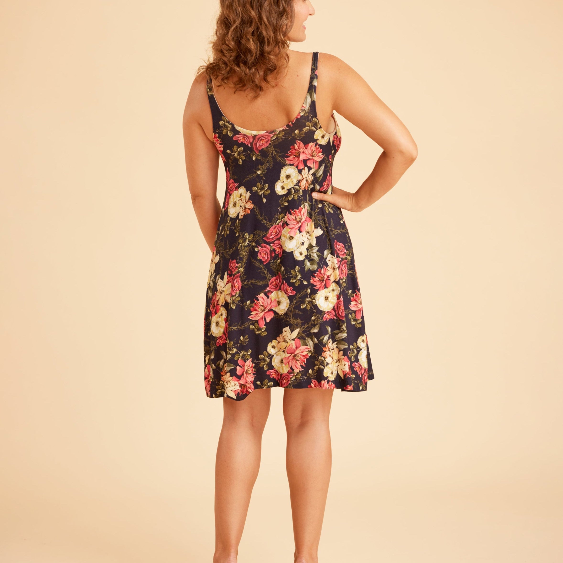 Woman wearing a floral dress on a beige background. This is the Fiske Sleepwear Set sewing pattern from Cashmerette.