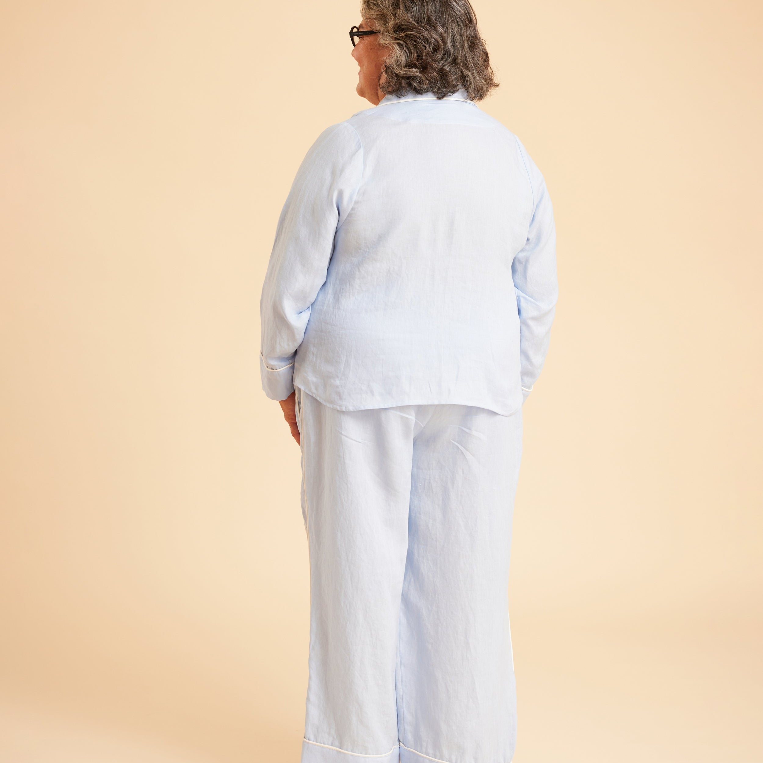 Person wearing a light blue outfit on a beige background. This is the Fiske Sleepwear Set sewing pattern from Cashmerette.