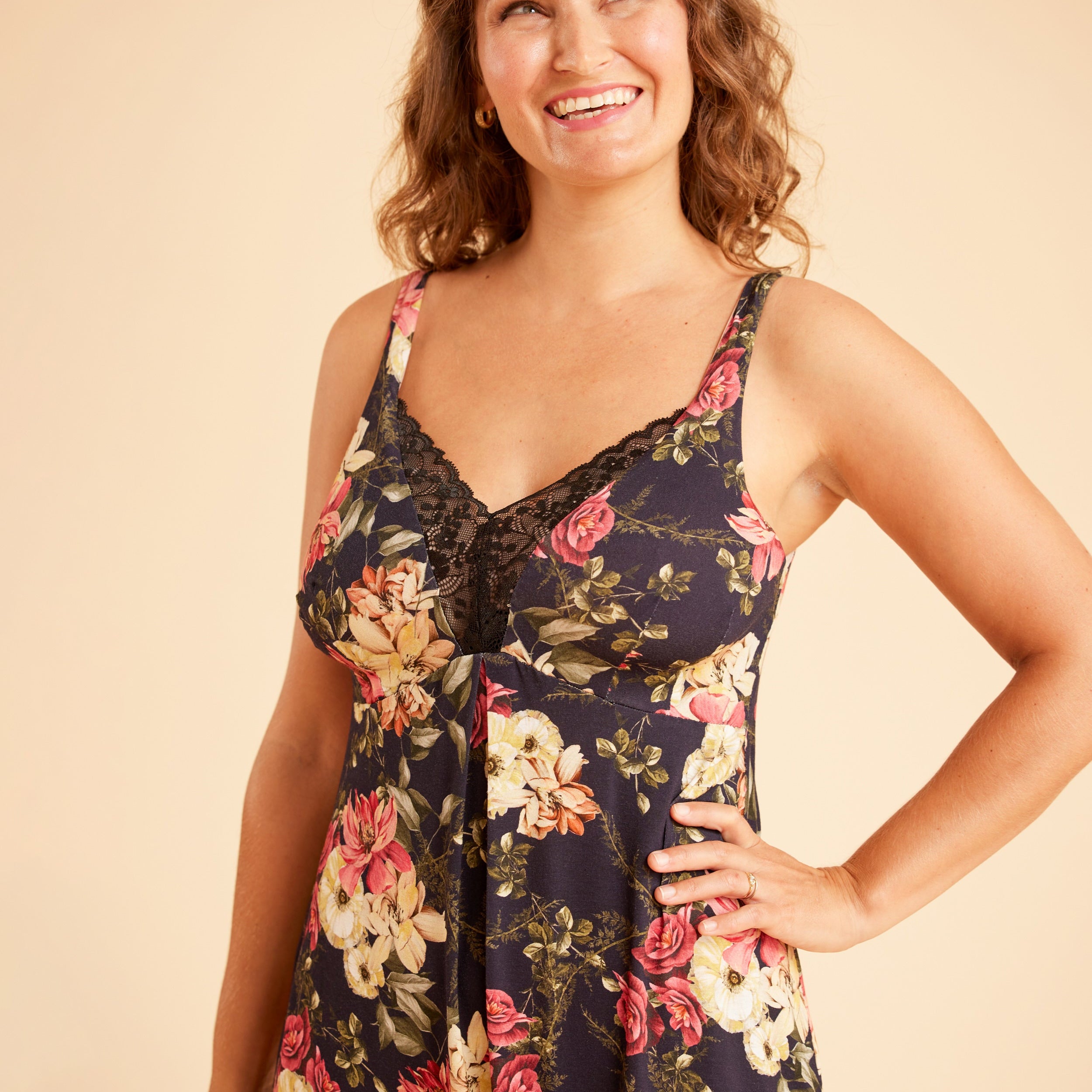 Woman wearing a floral dress against a beige background. This is the Fiske Sleepwear Set sewing pattern from Cashmerette.