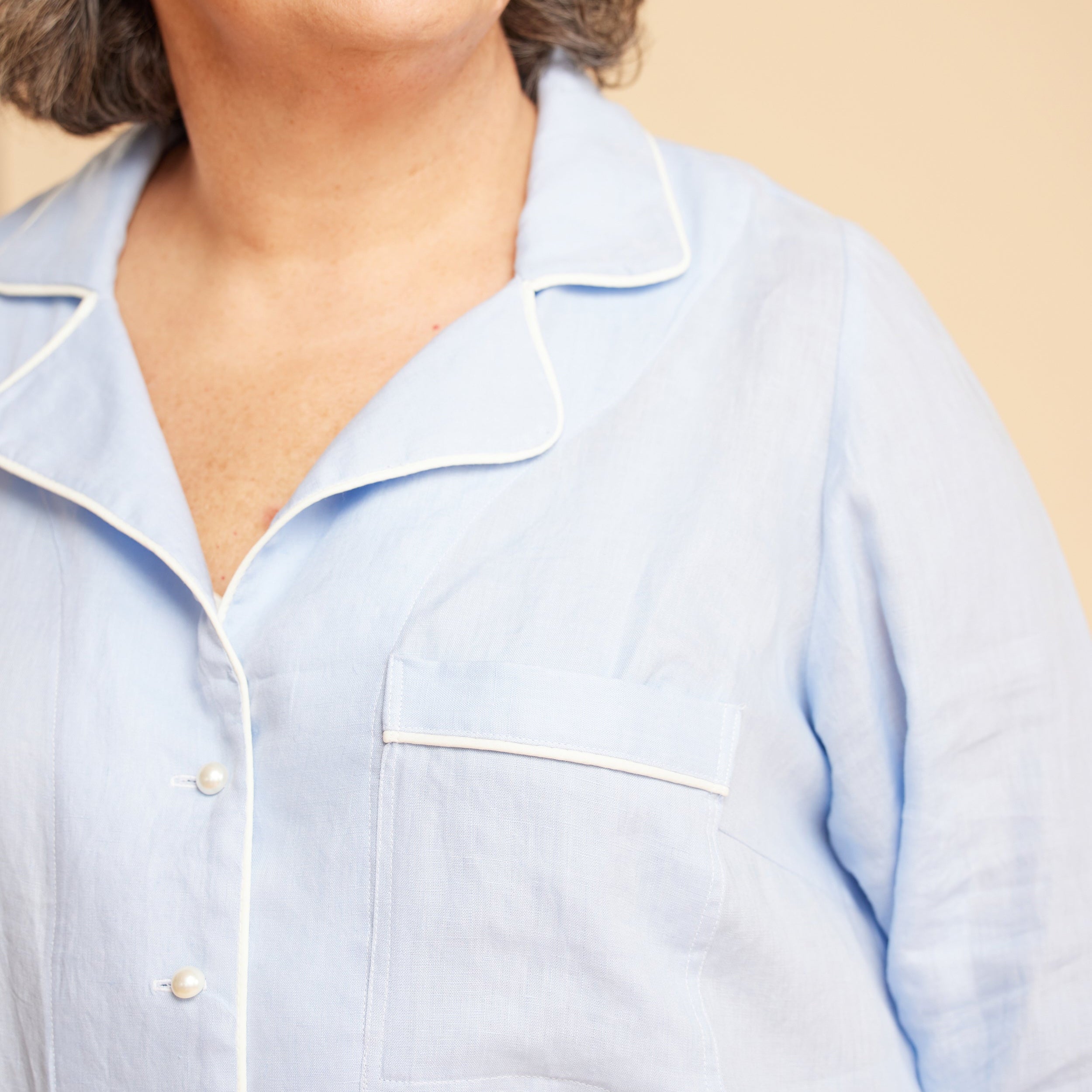 Light blue shirt worn by a person on a beige background. This is the Fiske Sleepwear Set sewing pattern from Cashmerette.