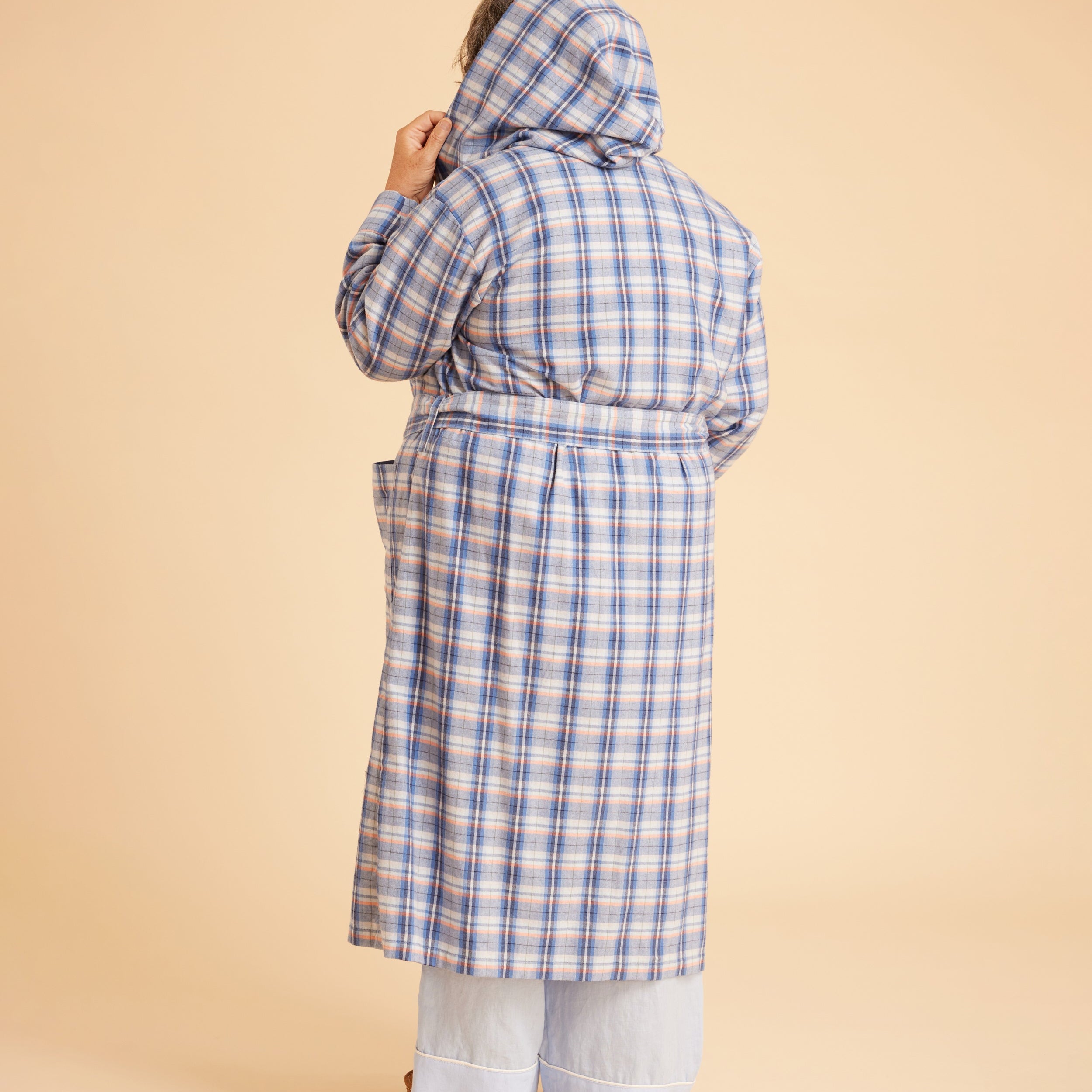 Person wearing a blue plaid coat on a beige background. This is the Fiske Sleepwear Set sewing pattern from Cashmerette.