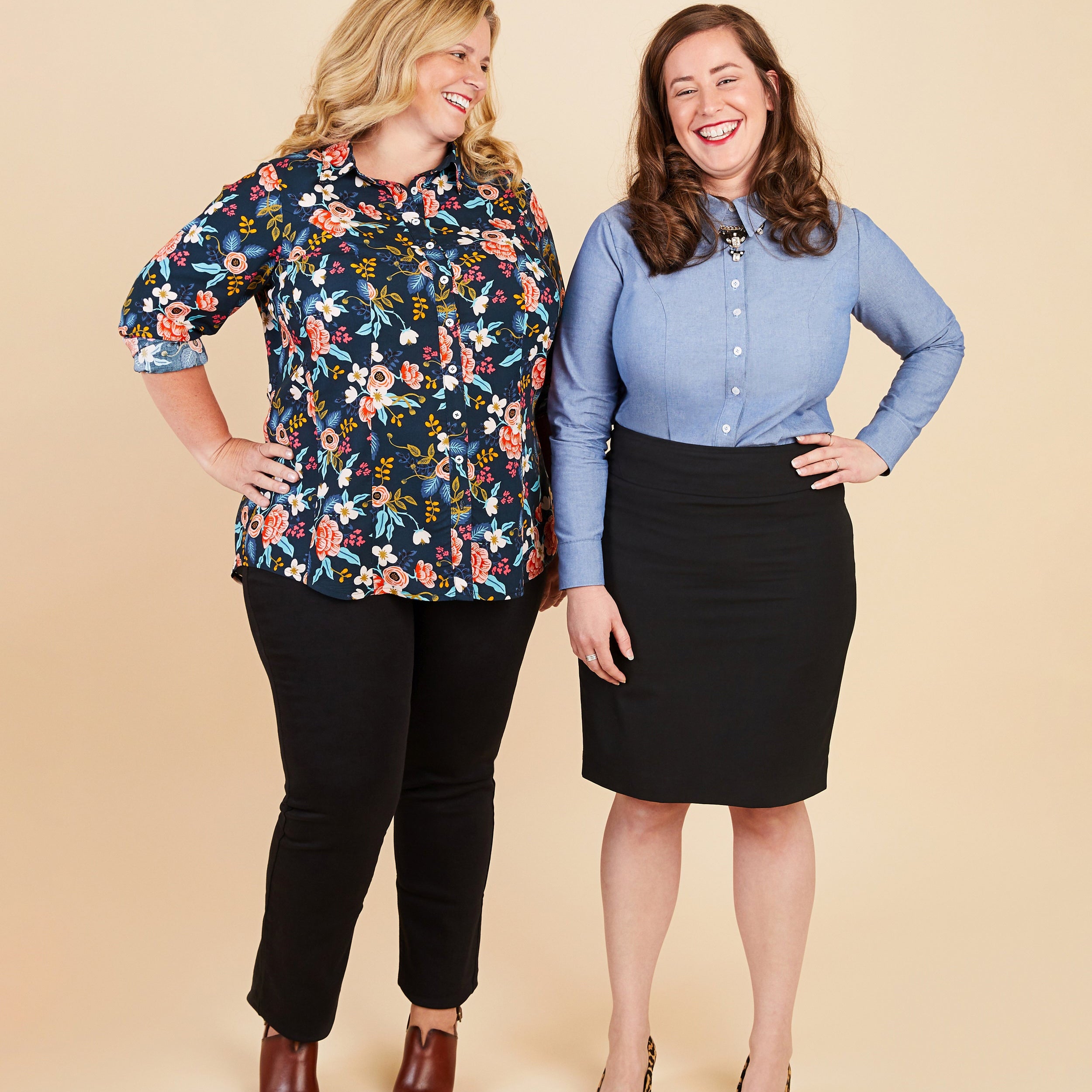 Two women standing side by side against a beige background, wearing colorful shirts and black pants.. This button-up shirt is the Harrison Shirt sewing pattern from Cashmerette.