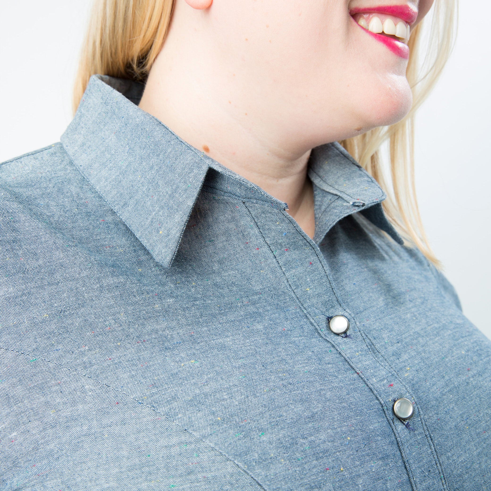 Person wearing a blue shirt with a collar against a plain background. This button-up shirt is the Harrison Shirt sewing pattern from Cashmerette.