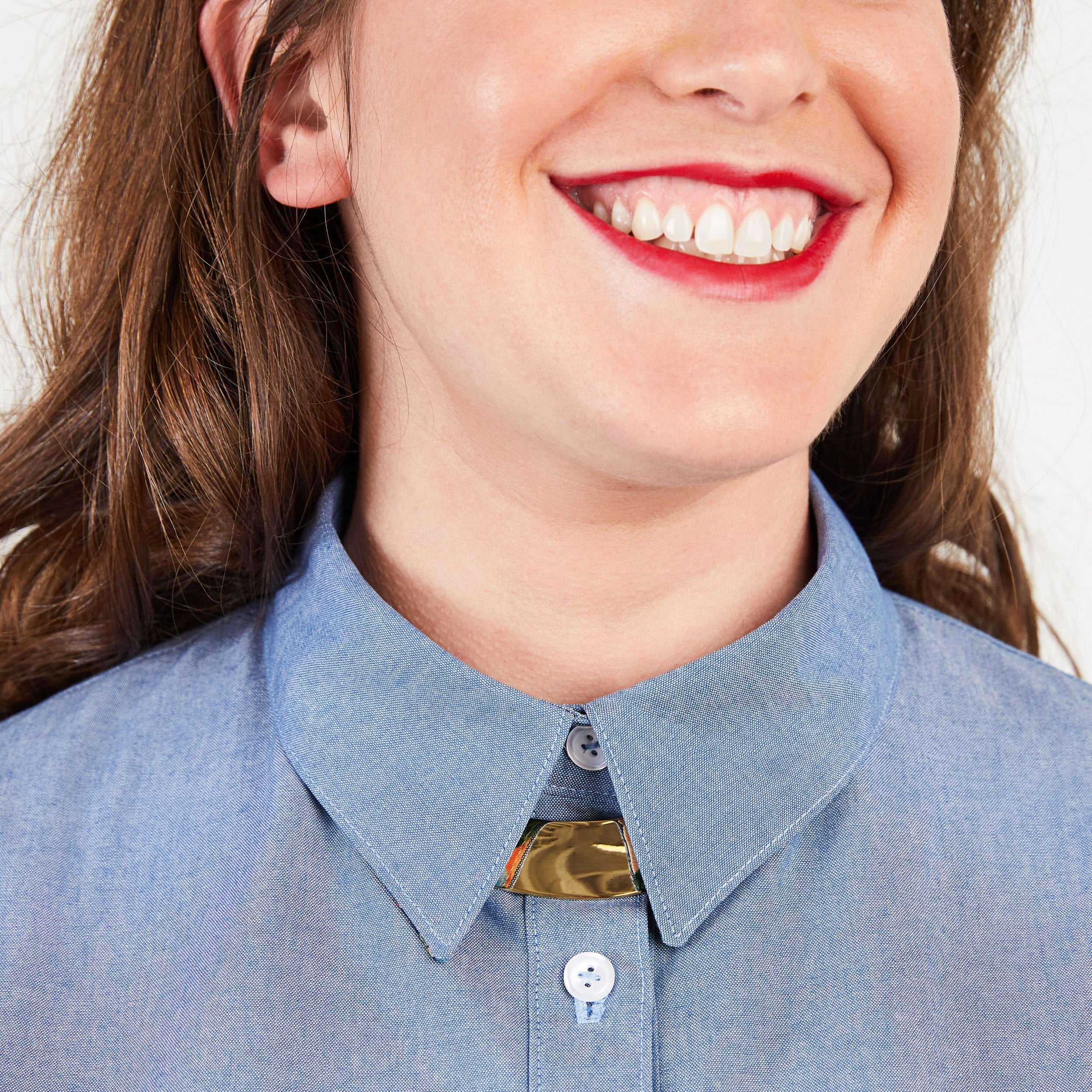 Close-up of a person wearing a blue shirt with a collar. This button-up shirt is the Harrison Shirt sewing pattern from Cashmerette.