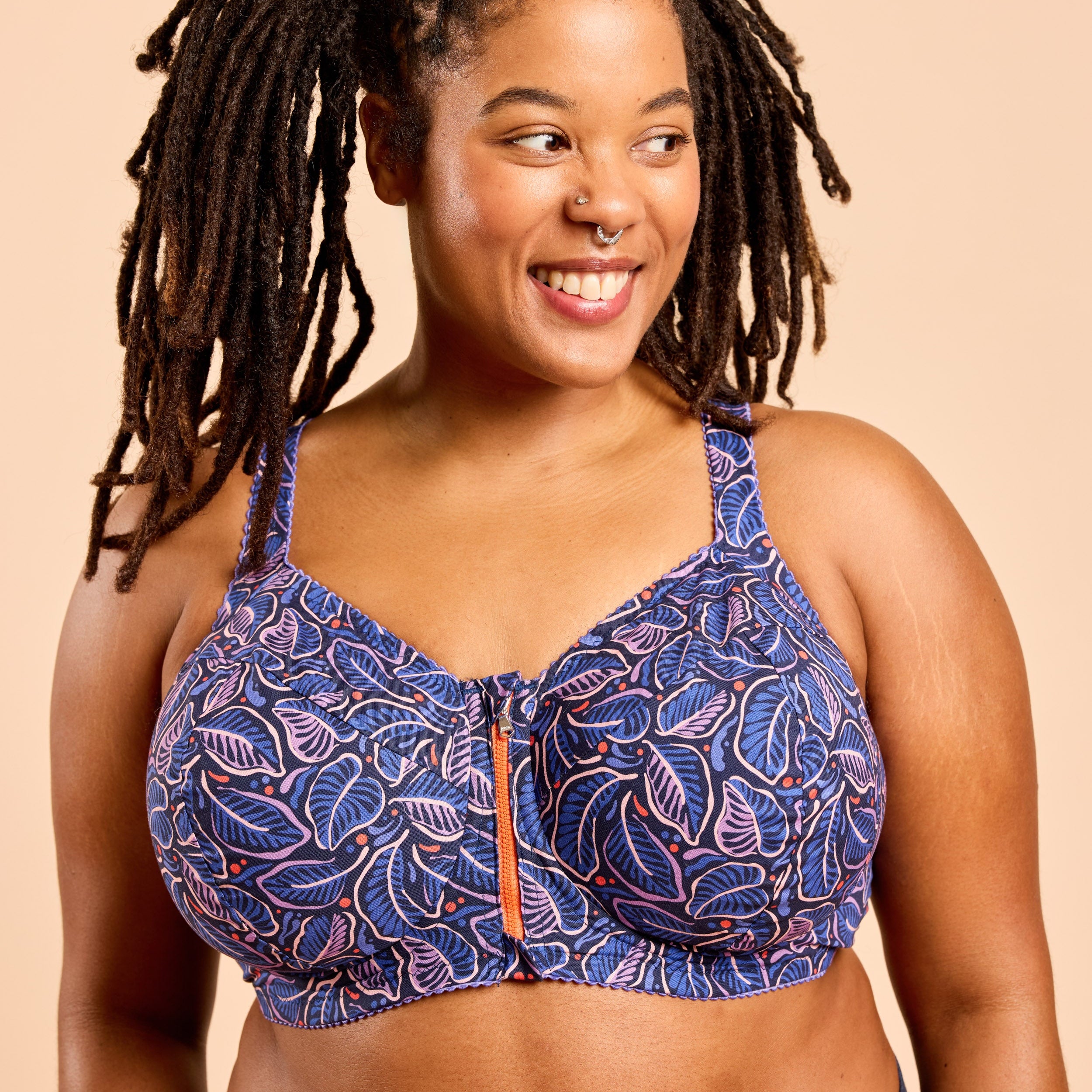 Woman wearing a blue patterned bra against a beige background. This is the Cashmerette Somerville Sports Bra sewing pattern for big boobs.