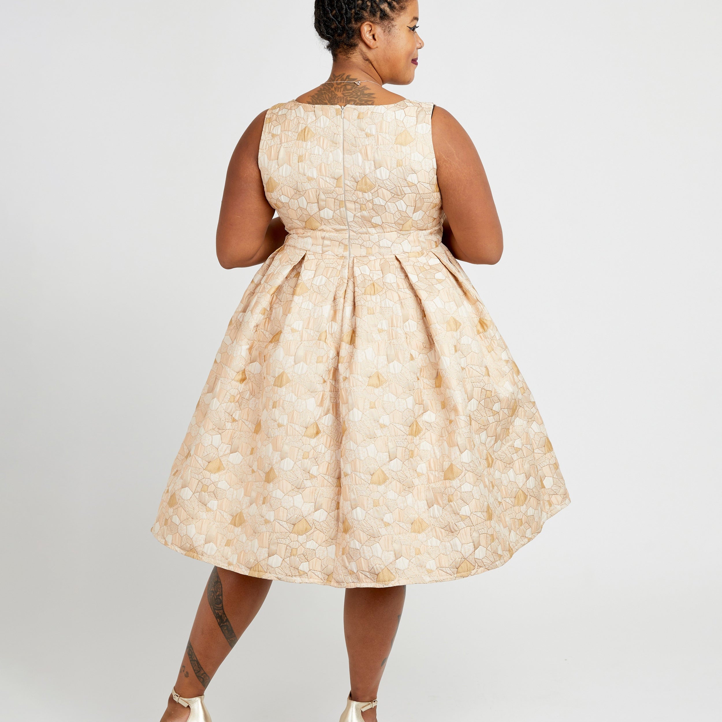 Woman wearing a beige floral dress on a white background. This dress is the Upton Dress & Skirt sewing pattern from Cashmerette.