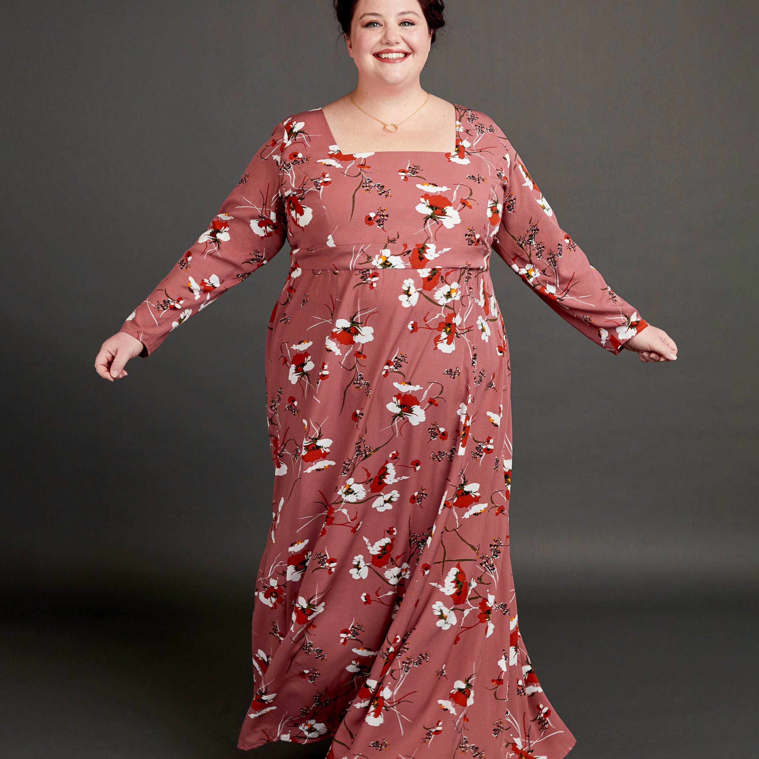 Woman wearing a long floral dress against a gray background. This dress is the Upton Dress & Skirt sewing pattern from Cashmerette.