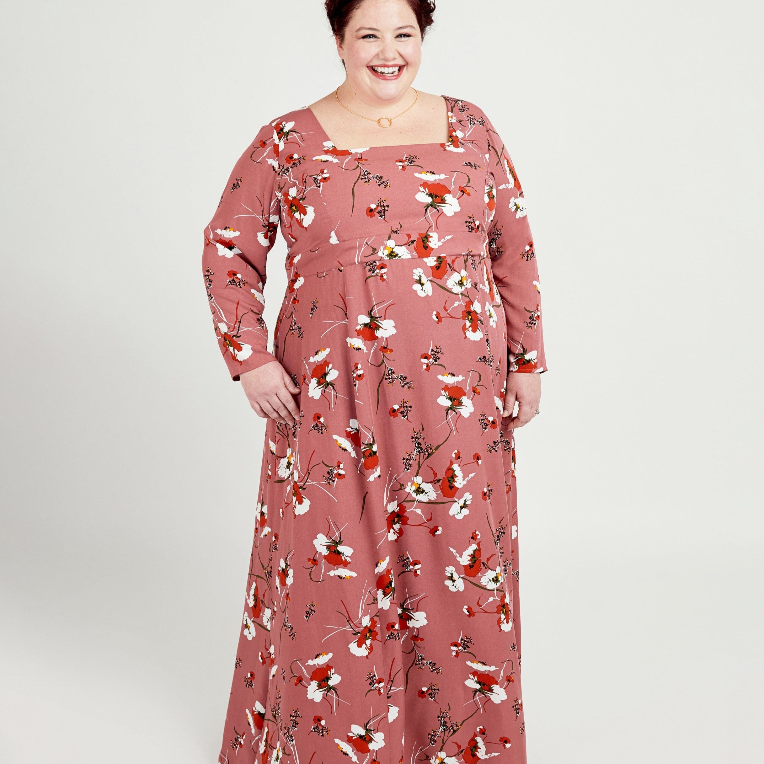 Woman wearing a floral dress on a white background. This dress is the Upton Dress & Skirt sewing pattern from Cashmerette.