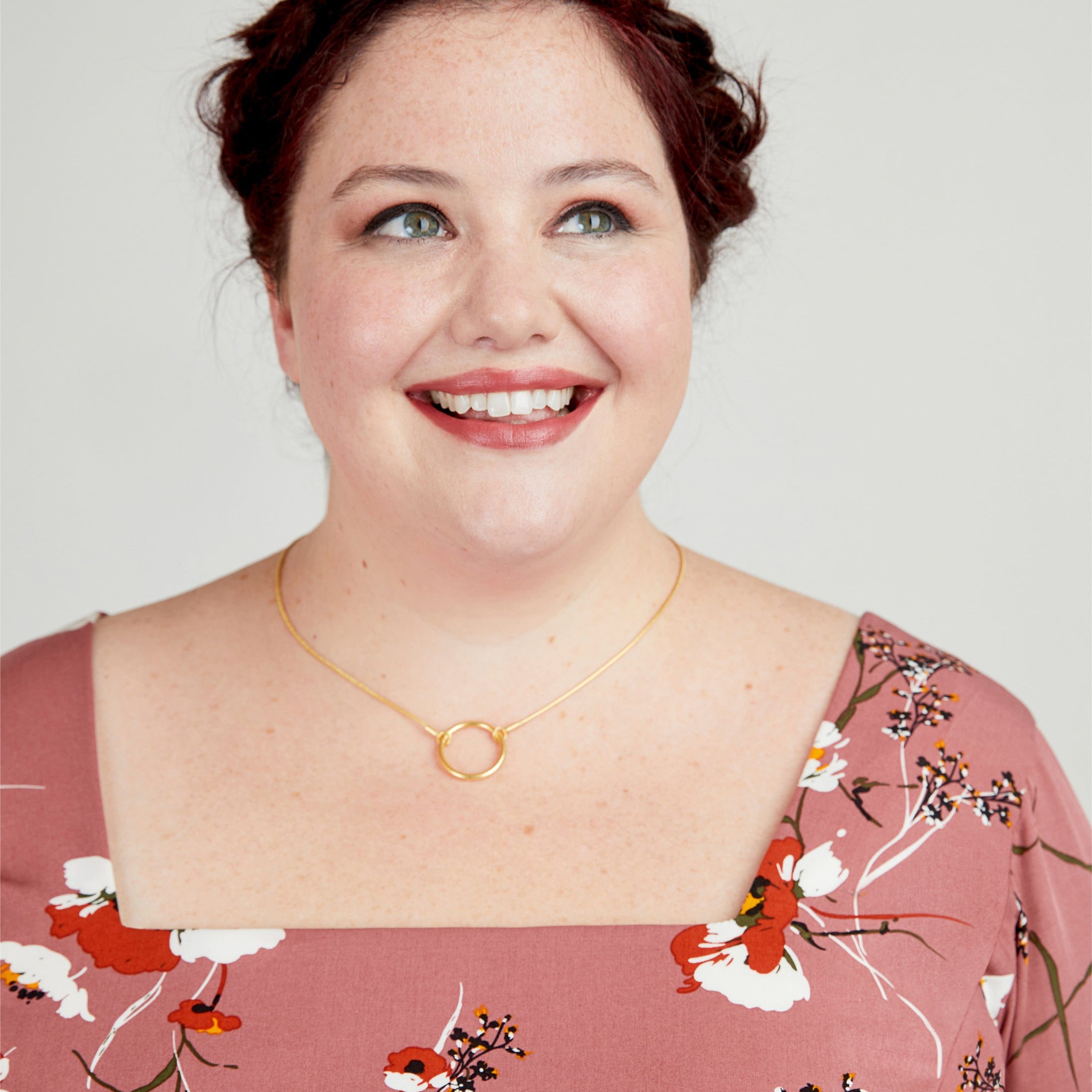 Woman wearing a floral dress with a plain background. This dress is the Upton Dress & Skirt sewing pattern from Cashmerette.