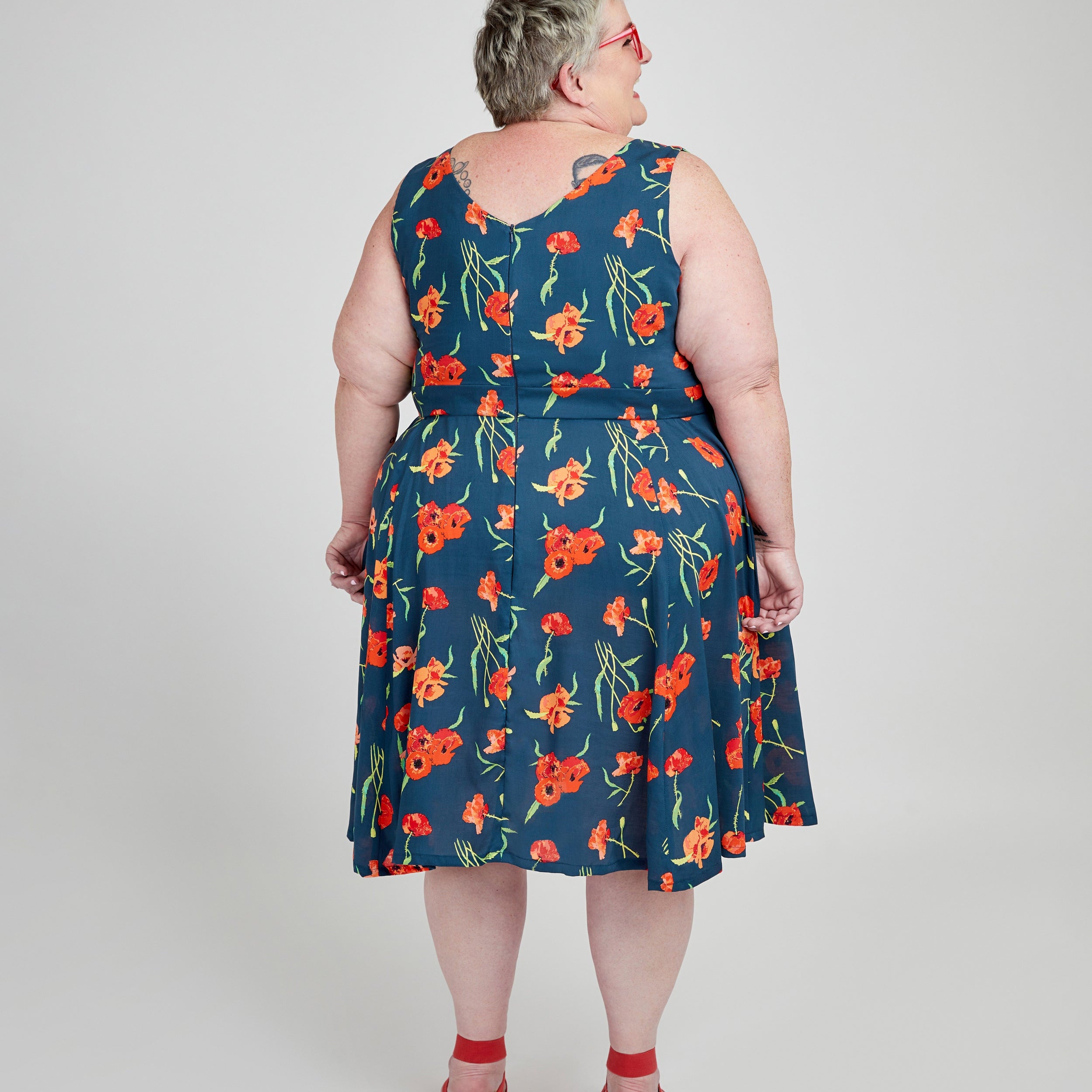 Woman wearing a blue floral dress on a white background. This dress is the Upton Dress & Skirt sewing pattern from Cashmerette.