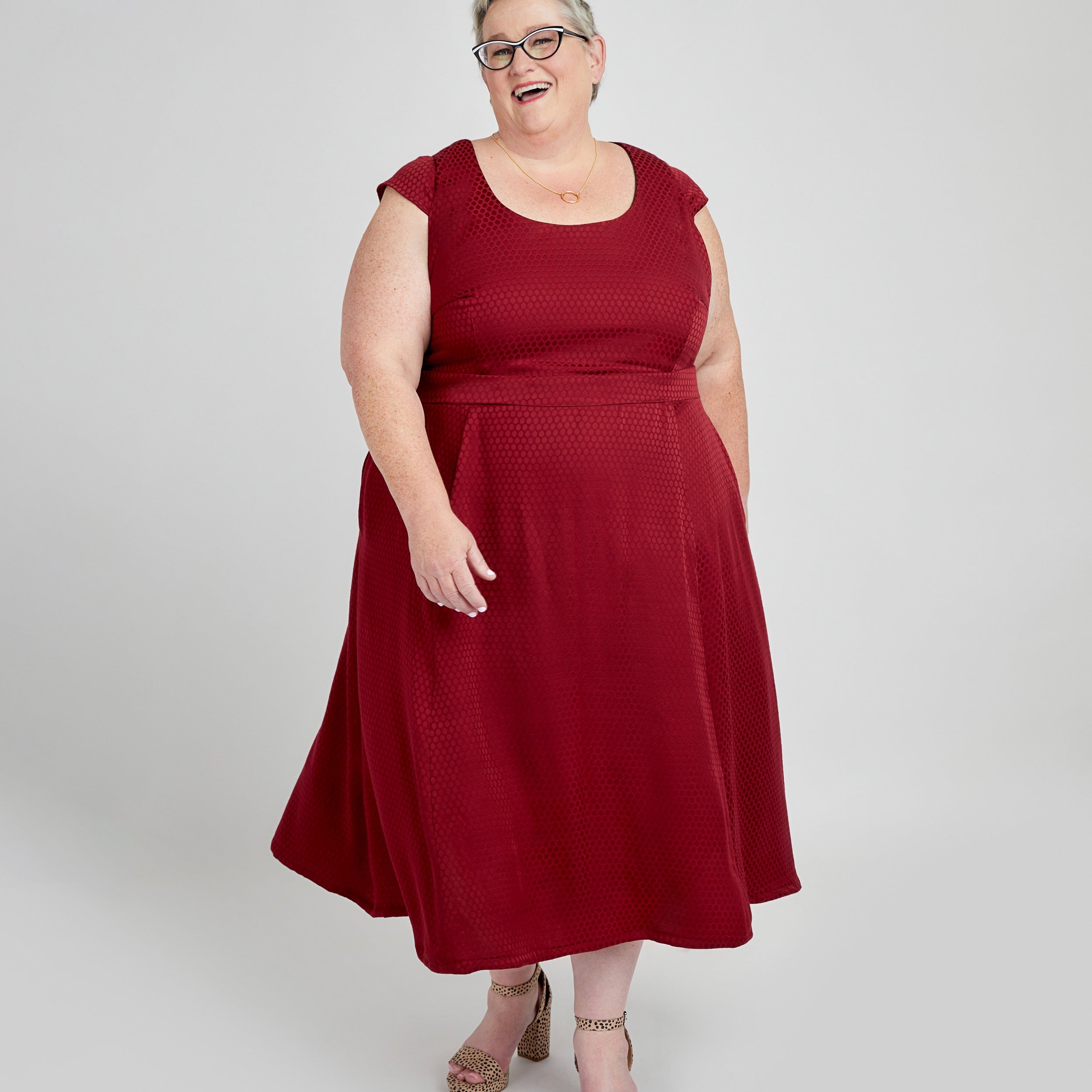 Woman wearing a red dress on a white background. This dress is the Upton Dress & Skirt sewing pattern from Cashmerette.