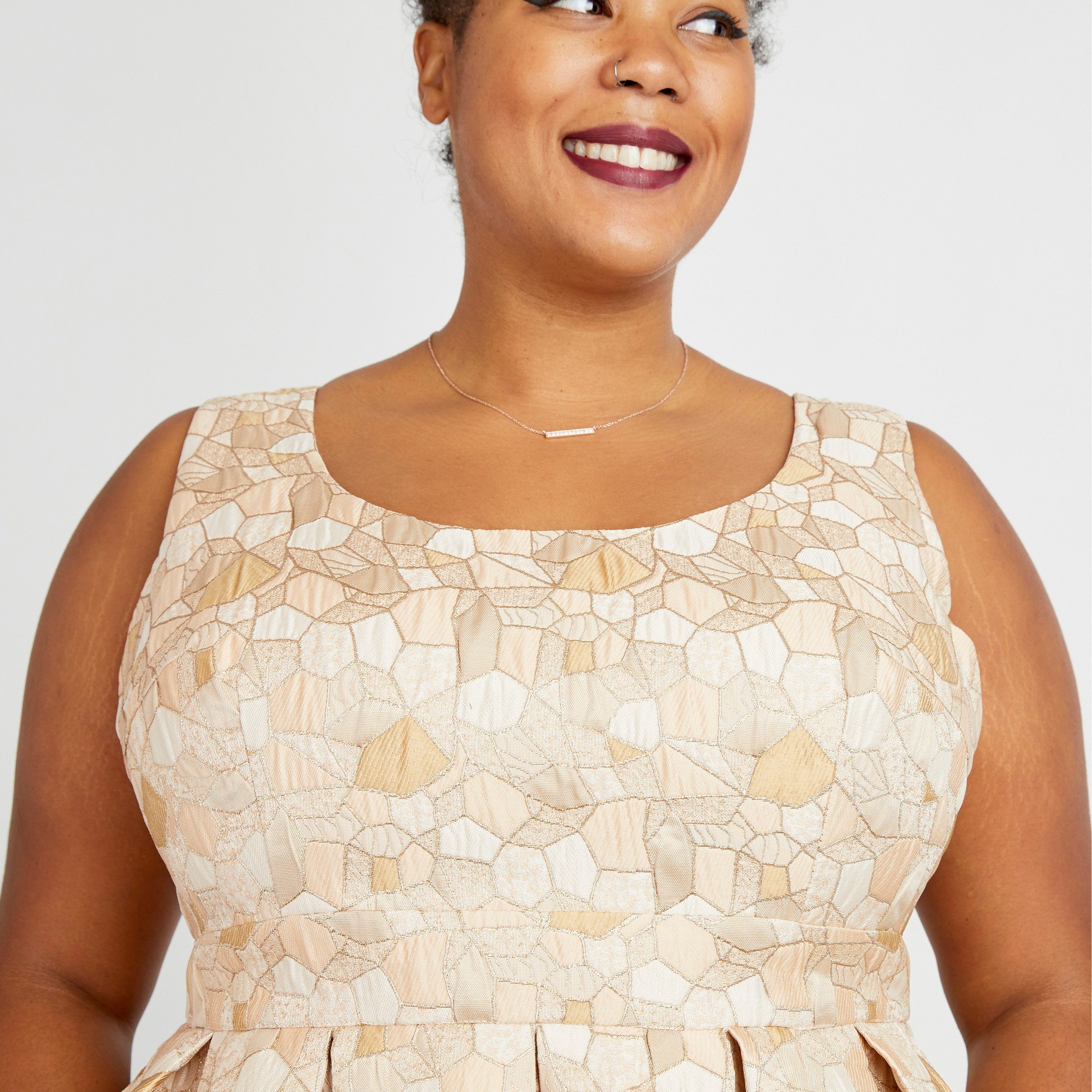 Woman wearing a beige patterned dress against a plain background. This dress is the Upton Dress & Skirt sewing pattern from Cashmerette.