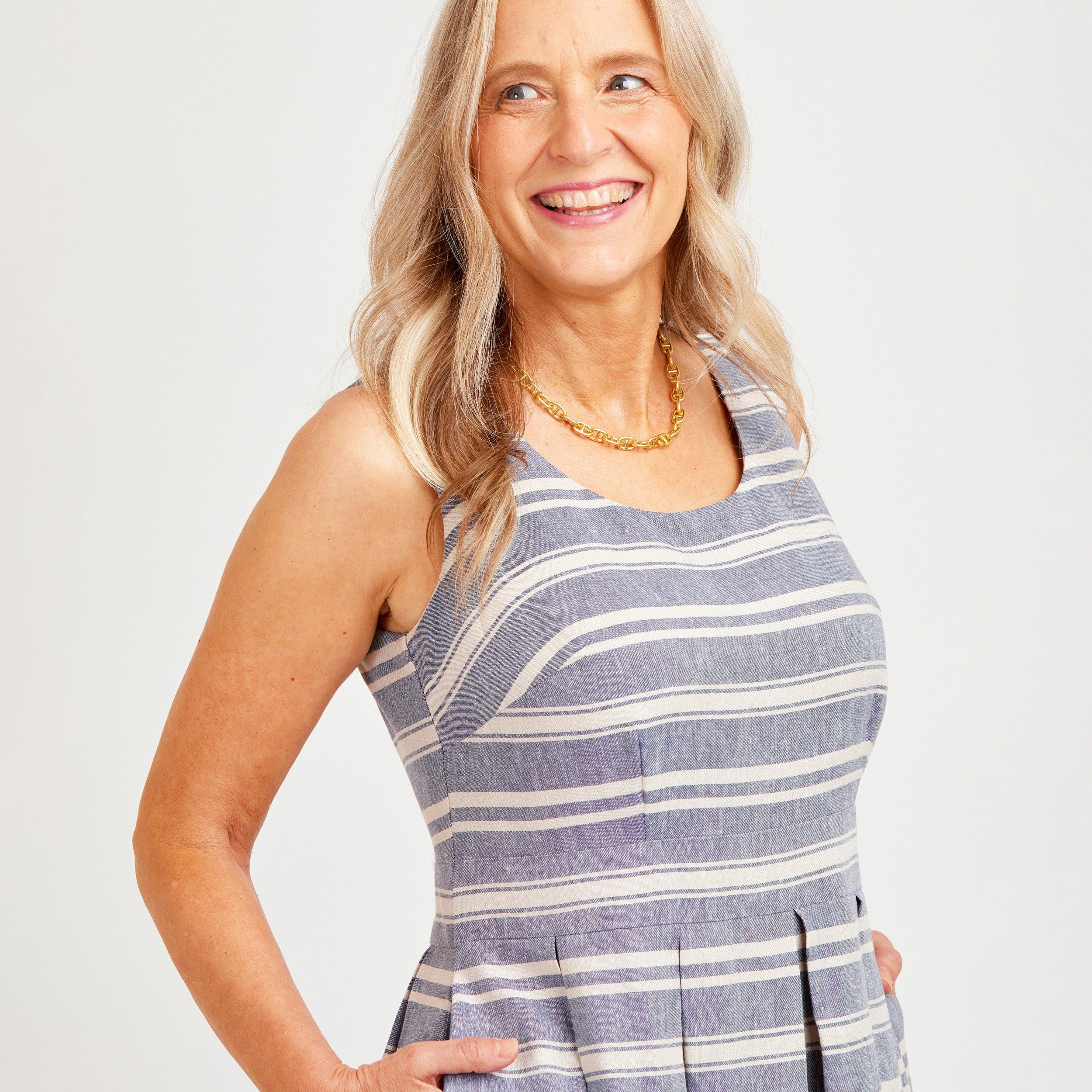 Woman wearing a blue and white striped dress against a plain background. This dress is the Upton Dress & Skirt sewing pattern from Cashmerette.