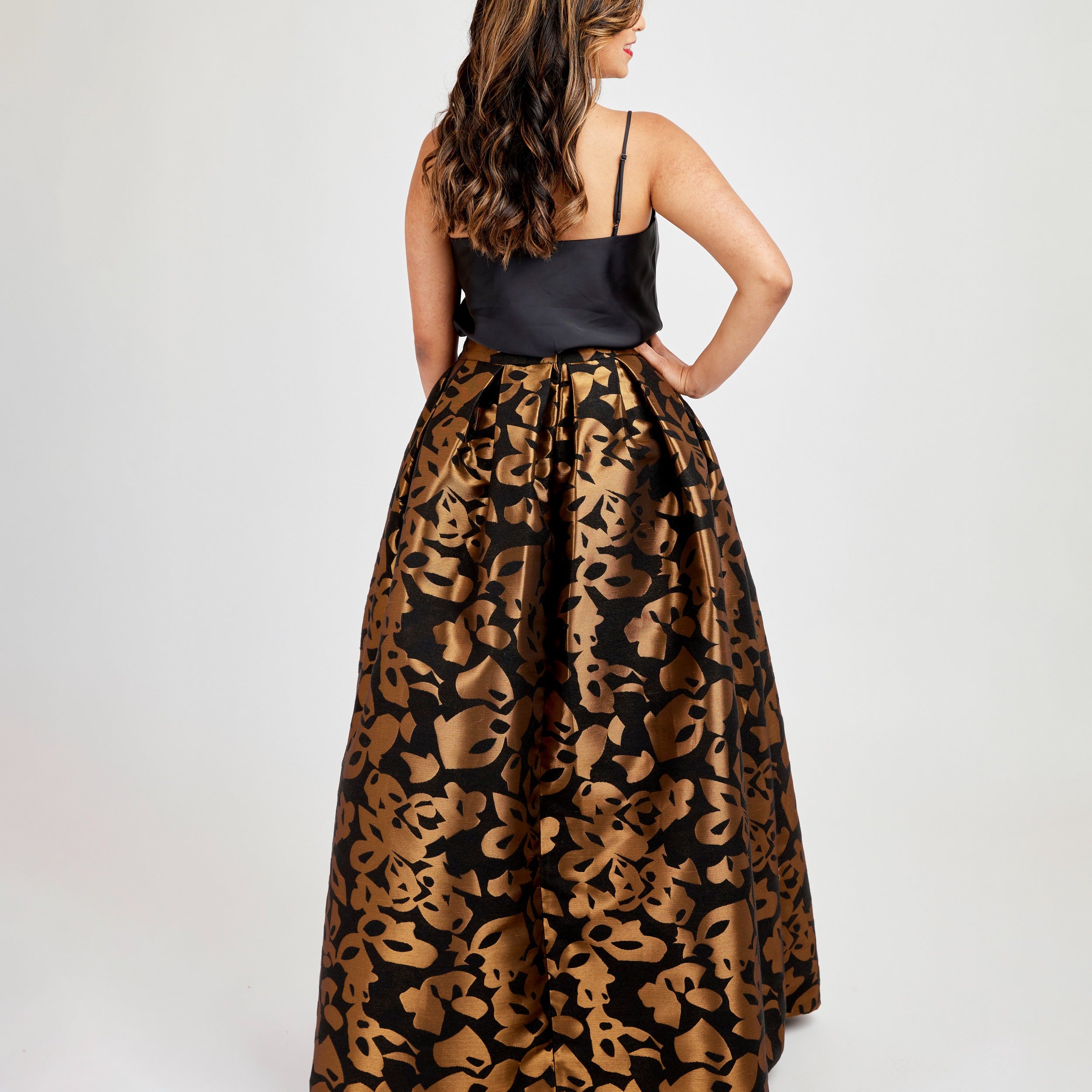 Woman wearing a black top and leopard print skirt on a white background. This skirt is the Upton Dress & Skirt sewing pattern from Cashmerette.