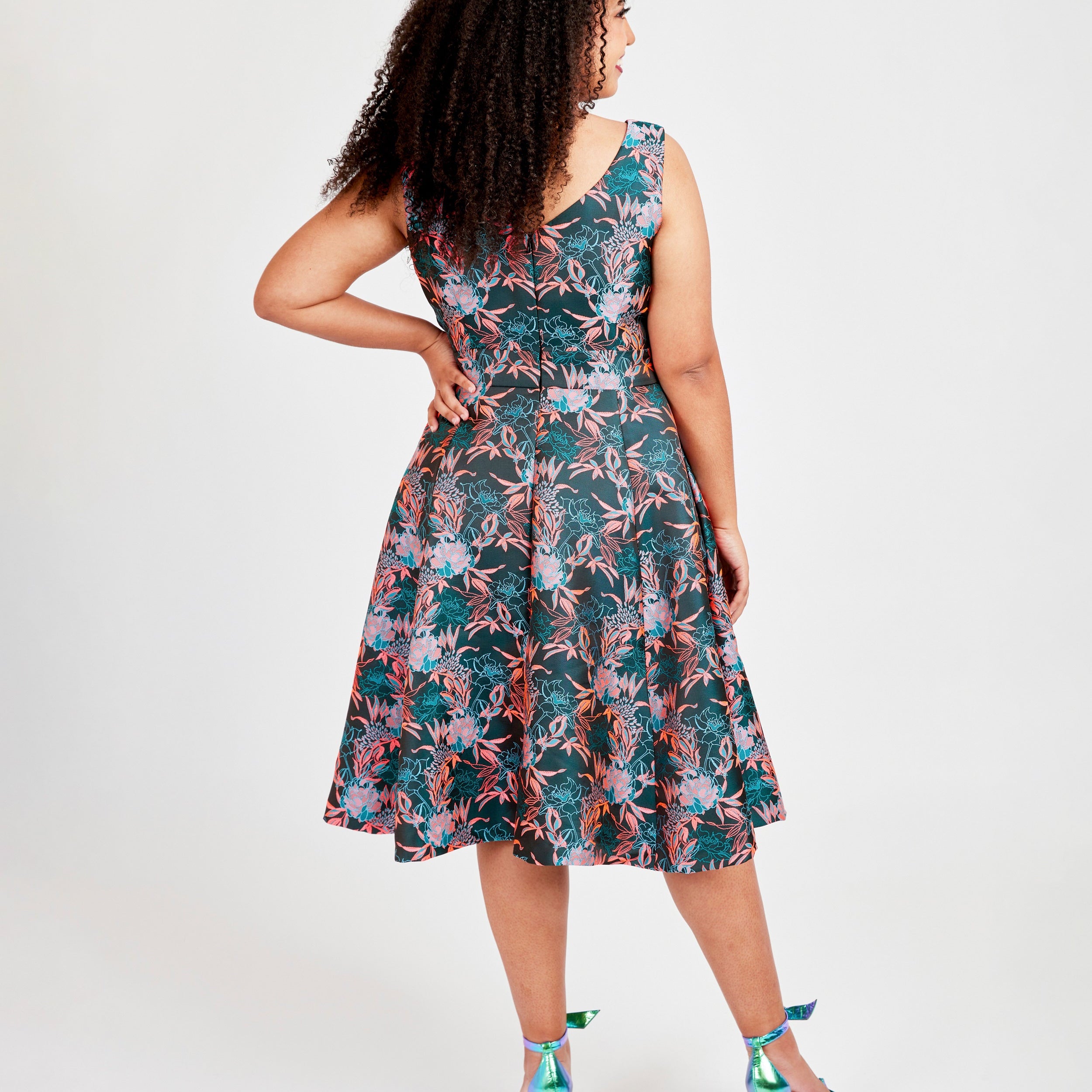Woman wearing a floral dress on a white background. This dress is the Upton Dress & Skirt sewing pattern from Cashmerette.