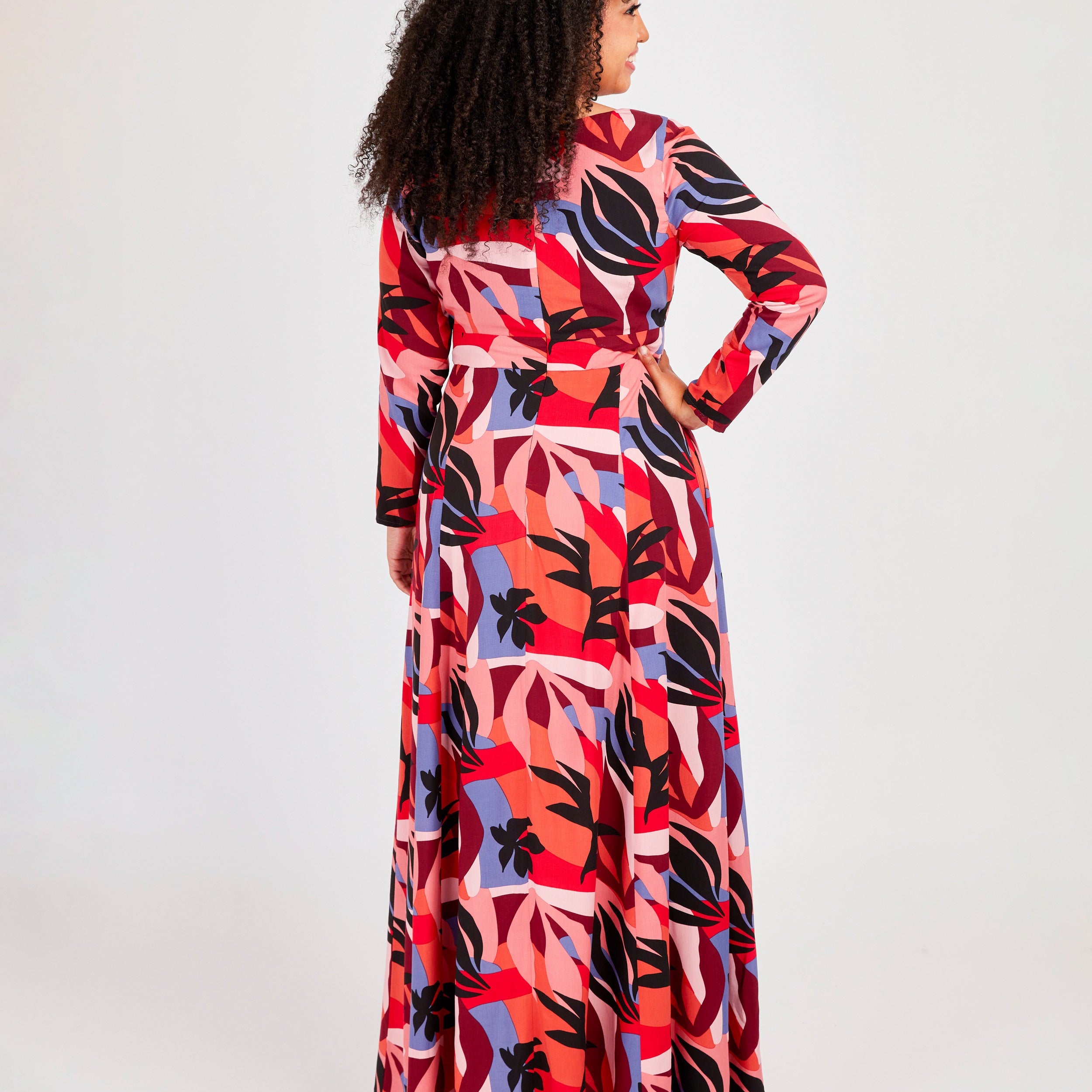 Woman wearing a colorful patterned dress on a white background. This dress is the Upton Dress & Skirt sewing pattern from Cashmerette.