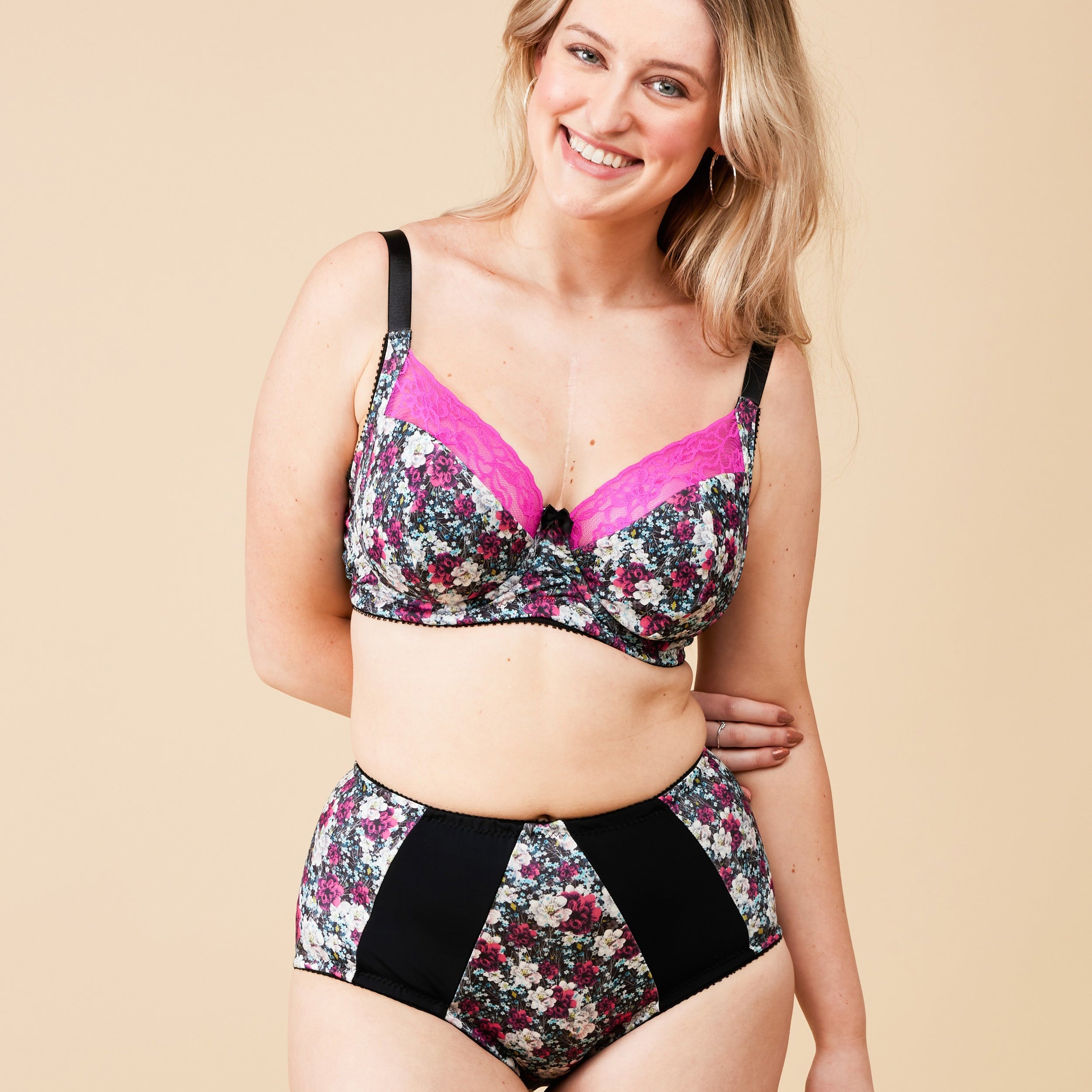 Woman wearing a floral lingerie set on a beige background. This bra is the Willowdale Bra sewing pattern from Cashmerette.