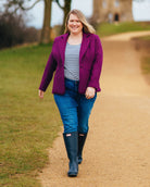 Woman in a purple coat, striped shirt, and blue jeans walking on a path outdoors.. This blazer is the Auburn Blazer sewing pattern from Cashmerette.