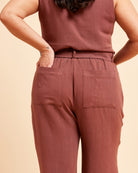 Person wearing a matching brown top and pants on a beige background. These pants are the Everett Pants & Shorts sewing pattern from Cashmerette.