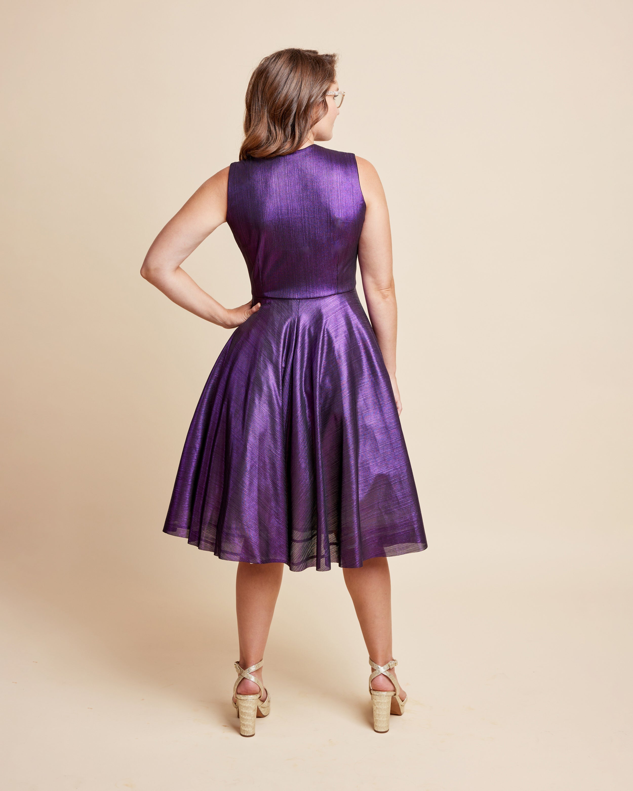 Woman wearing a purple dress against a beige background. This is the Grafton Dress, Top & Skirt sewing pattern from Cashmrette.