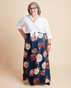 Woman wearing a white blouse and floral skirt on a beige background. This is the Grafton Dress, Top & Skirt sewing pattern from Cashmerette.