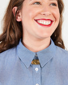 Close-up of a person wearing a blue shirt with a collar. This button-up shirt is the Harrison Shirt sewing pattern from Cashmerette.