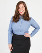 Woman wearing a blue button-up shirt and black skirt on a white background. This button-up shirt is the Harrison Shirt sewing pattern from Cashmerette.