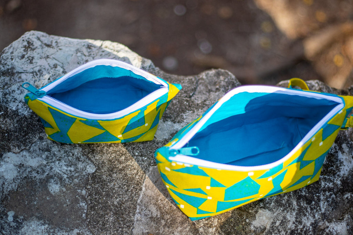 Image of yellow and blue Rivet Patterns Prelude Pouch sitting on rock