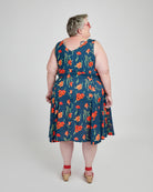 Woman wearing a blue floral dress on a white background. This dress is the Upton Dress & Skirt sewing pattern from Cashmerette.