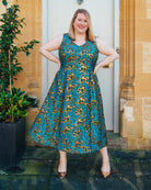 Woman wearing a blue and gold patterned dress standing outdoors. This dress is the Upton Dress & Skirt sewing pattern from Cashmerette.